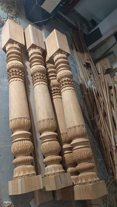 several wooden pillars are stacked on top of each other in the process of being carved