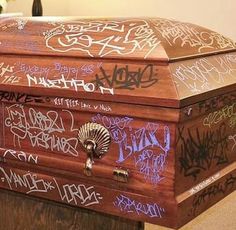 a chest covered in graffiti sitting on top of a table