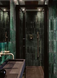 a green tiled bathroom with a walk in shower