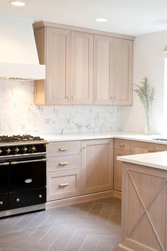 a kitchen with white marble counter tops and wooden cabinets, along with black stove top oven