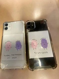 two cell phones with stickers on them are sitting next to each other in plastic cases