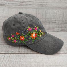 This beautiful women's baseball cap is hand embroidered with a bright floral pattern. It is a lovely piece to complete your everyday outfit or festive occasion wardrobe. The hand-stitched hat with wildflowers is a perfect gift for anyone who loves unique accessories. 💚 CAP DETAILS  *Color: gray(Charcoal). You can also choose other available colors from the variation list.  *One size fits most adults: head circumference is 22" - 28" (55 - 67 cm). *Fabric: 100% soft cotton twill, garment-washed, Handmade Cotton Hats As Gifts, Embroidered Cotton Hat As Gift, Adjustable Flower Hat As A Gift, Embroidered Snapback Hat As Gift, Embroidered Snapback Hat As A Gift, Summer Embroidered Baseball Cap With Curved Bill, Embroidered Cotton Baseball Cap As Gift, Spring Embroidered Hat For Gift, Handmade Hats As Spring Gifts