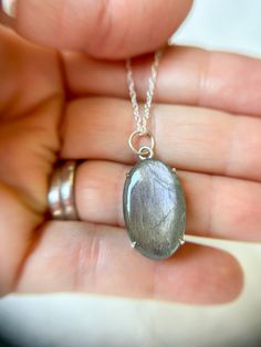 This gorgeous flashy oval Labradorite cabachon is delicately prong set in sterling silver and features an open back to light the light come in and sparkle! The necklace hangs from a graduated sized jump rings hanging on a 20” Sterling Silver Chain. Each piece of GreenHillJewelry is handmade in our El Dorado Hills, CA studio. We proudly use Recycled Sterling Silver. Please allow for natural variations that may occur.This order will ship in 1-2 business days via first class USPS unless Priority Sh Iridescent Oval Sterling Silver Jewelry, Silver Labradorite Oval Pendant Jewelry, Oval Pendant Jewelry With Natural Inclusions In Silver, Oval Labradorite Necklace With Large Stone, Elegant Oval Labradorite Pendant Jewelry, Oval Silver Labradorite Jewelry, Silver Oval Labradorite Necklace, Oval Labradorite Silver Necklace, Iridescent Oval Gemstone Necklaces