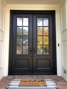 a black double door with two sidelights and brick steps