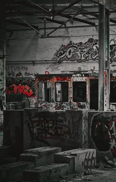 an abandoned building with graffiti all over the walls and floor, along with concrete blocks