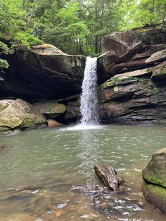 there is a waterfall in the middle of some rocks and water that is flowing over it