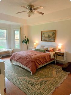 a bedroom with a bed, rug and ceiling fan