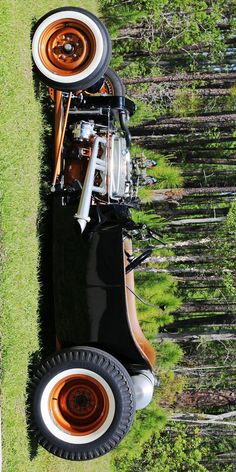 an orange and black car is parked in the grass