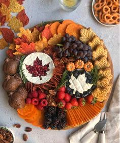 a platter filled with fruit and nuts on top of a table