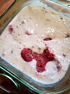 a glass casserole dish filled with cream cheese and red velvet crumbs