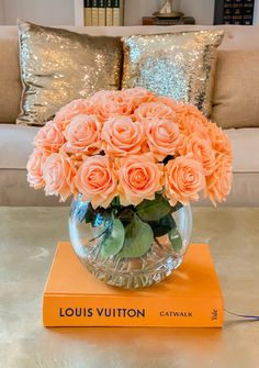 a vase filled with pink roses sitting on top of a table next to a couch