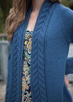 a woman wearing a blue cardigan sweater