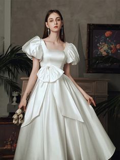 a woman in a white wedding dress posing for the camera