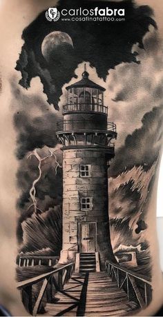 a man's back with a lighthouse tattoo on it