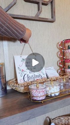 a person holding a sign above a shelf filled with christmas decorations and other holiday items