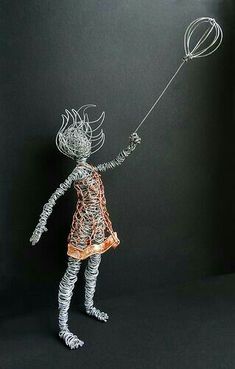 a wire sculpture of a girl holding a balloon