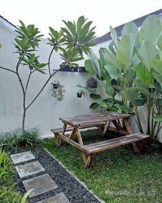 a wooden bench sitting in the middle of a lush green yard