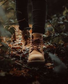 a person walking in the woods wearing brown boots