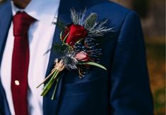 a man wearing a suit and tie with a boutonniere on his lapel