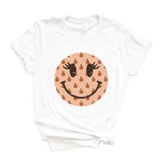 Looking for a cute versatile top to wear this summer? Make sure to grab one of our Smiley Face Peaches tees! This soft and comfortable graphic tee is the perfect top for any outfit. It can be paired with biker shorts, jeans, or even a simple skirt/dress! This tee is true-to-size, so be sure to order your regular t-shirt size! If you are looking for a more oversized look, make sure to size up! Playful Crew Neck T-shirt For Fall, Playful Orange Crew Neck Top, Playful Orange Summer T-shirt, Casual Orange Fruit Print Top, Graphic Tee With Fruit Print And Crew Neck, Fruit Print Graphic Tee With Crew Neck, Fruit Print Crew Neck Graphic Tee, Crew Neck Graphic Tee With Fruit Print, Playful Orange Graphic Print Tops