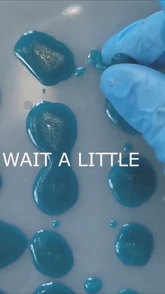 a person in blue gloves and rubber gloves is washing rocks with the words wait a little above them