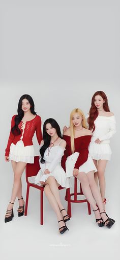 three women in red and white dresses sitting on chairs with their arms around each other