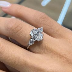 a woman's hand with a diamond ring on her finger and an engagement band