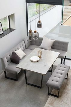 a modern living room with grey couches and white table in front of large windows