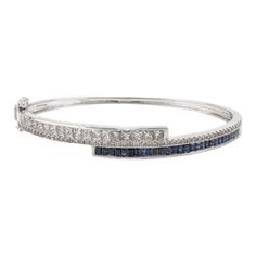 This is part of Chairish’s Fine Jewelry assortment.  This Brilliant Diamond and Blue Sapphire Cuff Bracelet in 18K gold showcases endlessly sparkling natural blue sapphire of 1.47 carats and 2 carats diamonds. Sapphire stimulates concentration and reduces stress.  Designed with perfect baguette cut blue sapphire and square cut diamonds studded in it to make you stand out on any occasion or event. The elegant style complements the attire beautifully and is a perfect Engagement Gift, Bridal Shower Fine Jewelry Sapphire Bangle Bracelet, Blue Diamond Bangle Fine Jewelry Bracelet, Blue Diamond Bangle Bracelet Fine Jewelry, Blue Diamond Bangle Bracelet In Fine Jewelry Style, Blue Diamond Bangle Bracelet With Accents, Sapphire Bangle Bracelet For Formal Occasions, White Gold Sapphire Bracelet In Fine Jewelry Style, Fine Sapphire Bangle Jewelry, Luxury Sapphire Bangle Bracelets