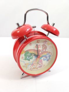 a red alarm clock sitting on top of a white table