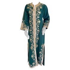 Elegant vintage Moroccan green caftan, poly jersey embroidered with black and gold threads design all-over. You could wear this maxi dress kaftan closed or open. The kaftan features a traditional neckline, with side slits and gently fluted embellished sleeves. It closes at the front with woven gold buttons and loops, could be open all the way down. Marrakech Bohemian, Yves Saint Laurent style. This Bohemian vintage 1970s style caftan is in perfect condition, dry cleaned and ready to wear. Size m Velvet Caftan, Emerald Green Maxi Dress, Moroccan Green, Dress Kaftan, 1970s Style, Designer Maxi Dress, Emo Dresses, Moroccan Caftan, African Traditional Dresses