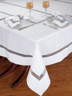 a table with two wine glasses on it and silverware sitting on top of the table