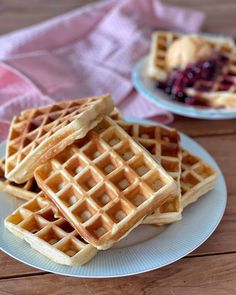 waffles stacked on top of each other on a white plate with blueberries