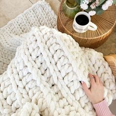 a woman is laying on the floor under a blanket with her hand resting on it