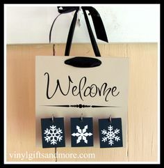 a welcome sign with snowflakes hanging from it's hooks on a wall