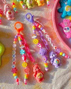 many different toys are laying on the ground next to a pink bowl and plastic spoon