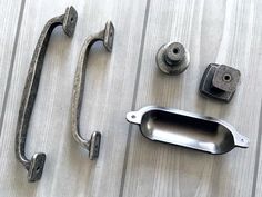 an assortment of metal handles and knobs on a wooden surface