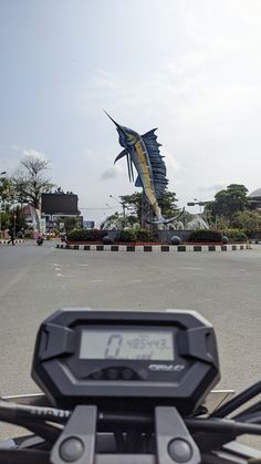 there is a clock on the handlebars of a motorcycle in front of a building