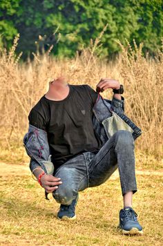 a man sitting on the ground with his hands in his pockets and looking up at something