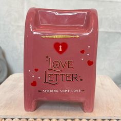 a red love letter box sitting on top of a wooden table