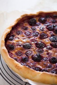 a blueberry pie sitting on top of a cooling rack