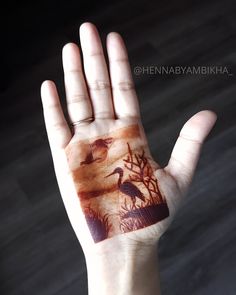 a person's hand with an animal and tree design painted on the inside of it