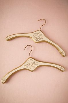 two wooden hangers that say bridesmaid and maid