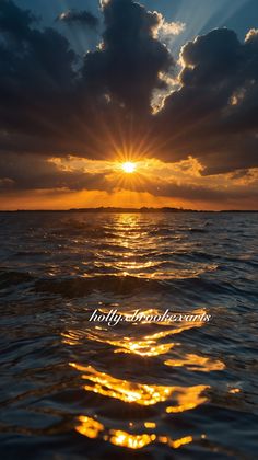 the sun is setting over the ocean with clouds in the sky and water below it