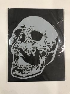 a white and black sticker with a skull on it's face is shown