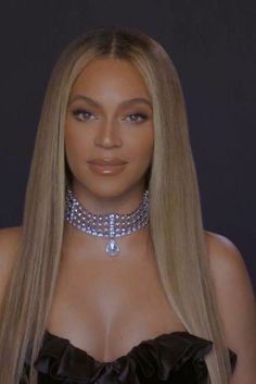 a woman with long blonde hair wearing a choker and diamond necklaces on her neck