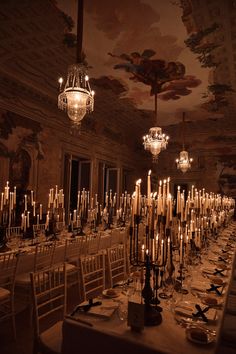 an elegant dining room with chandeliers and candles