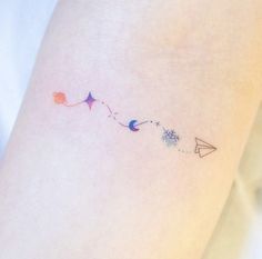 a woman's arm with an arrow and stars tattoo on the left side of her leg