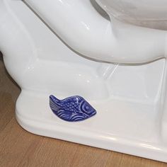 a blue fish sitting on top of a white toilet