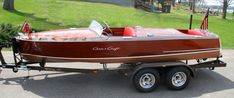 a red and brown boat sitting on top of a trailer